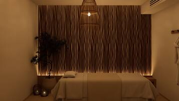 A spa room with a bed, a hanging light fixture, and a textured wall.
