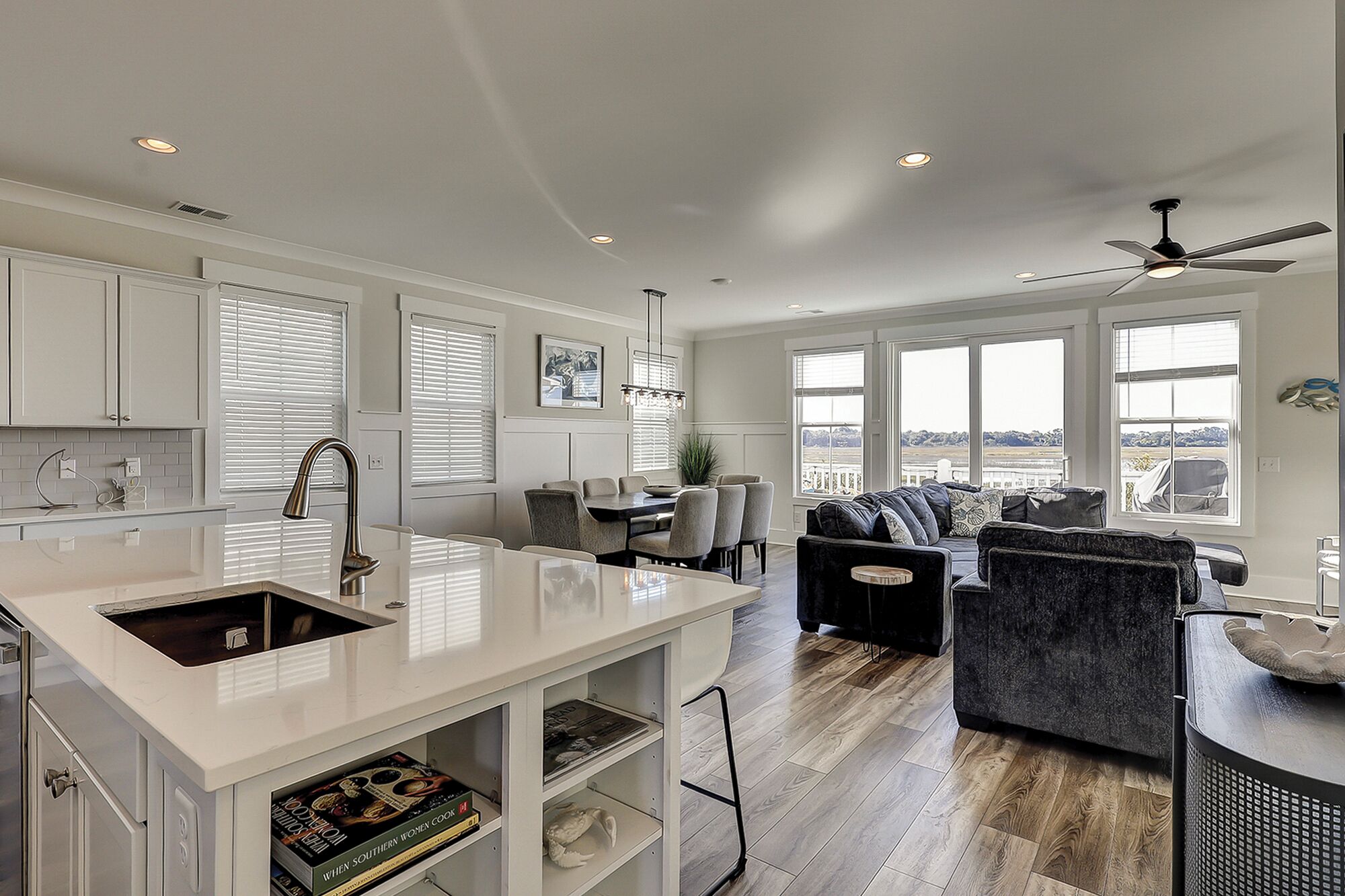 A spacious kitchen with a large island, dining area, and a view of the outdoors.