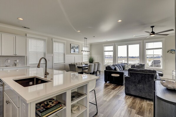 A spacious kitchen with a large island, dining area, and a view of the outdoors.