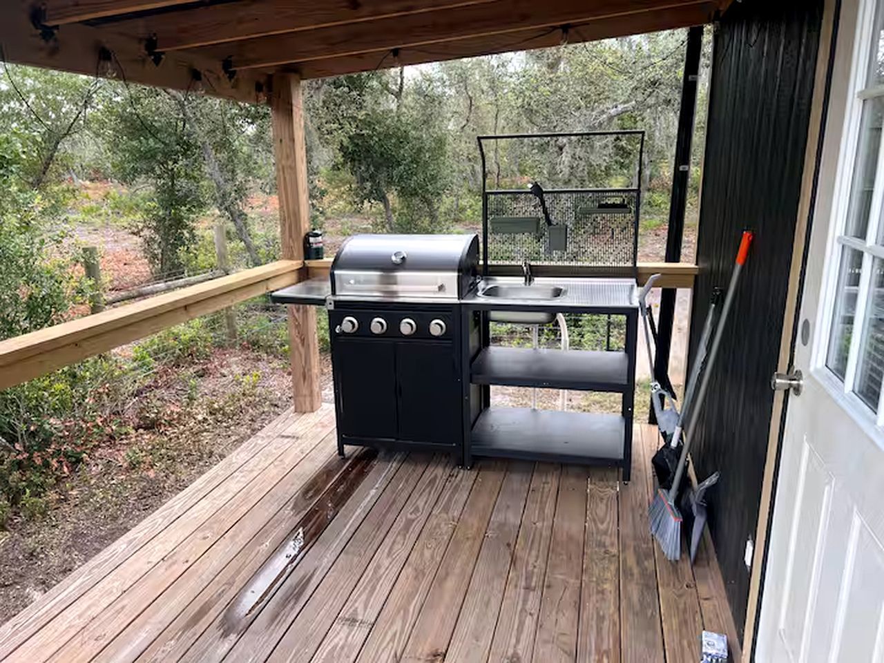 A wooden deck with a grill and a table.