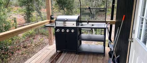 A wooden deck with a grill and a table.