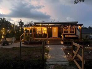 A house with a porch, outdoor seating, and string lights.
