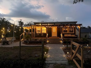 A house with a porch, outdoor seating, and string lights.