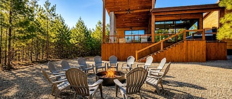 A modern wooden building with a fire pit and outdoor seating.