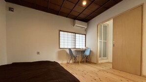 A bedroom with a large bed, a desk with chairs, a window, and a wardrobe. - Old-style inn Hinataya　Double room (中津川市)