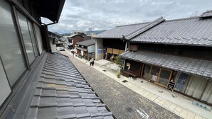 A traditional Japanese street with buildings featuring tiled roofs and wooden structures. - Old-style inn Hinataya　Double room (中津川市)