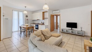 Un appartement moderne comprenant un salon, une cuisine, un coin repas et un téléviseur.