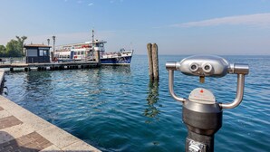 Un plan d’eau avec un quai, un bateau et une structure métallique équipée de jumelles.