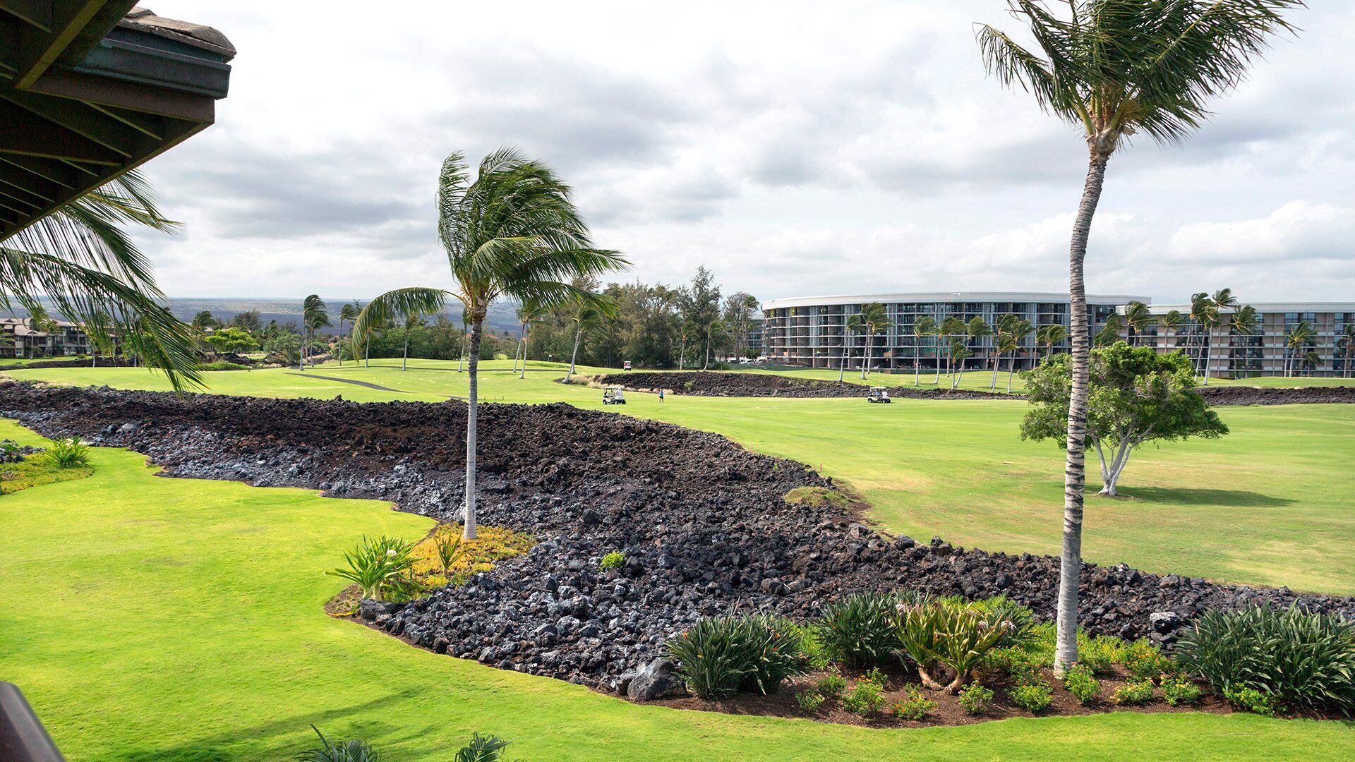 Ein Golfplatz mit Blick auf ein Hotel im Hintergrund.