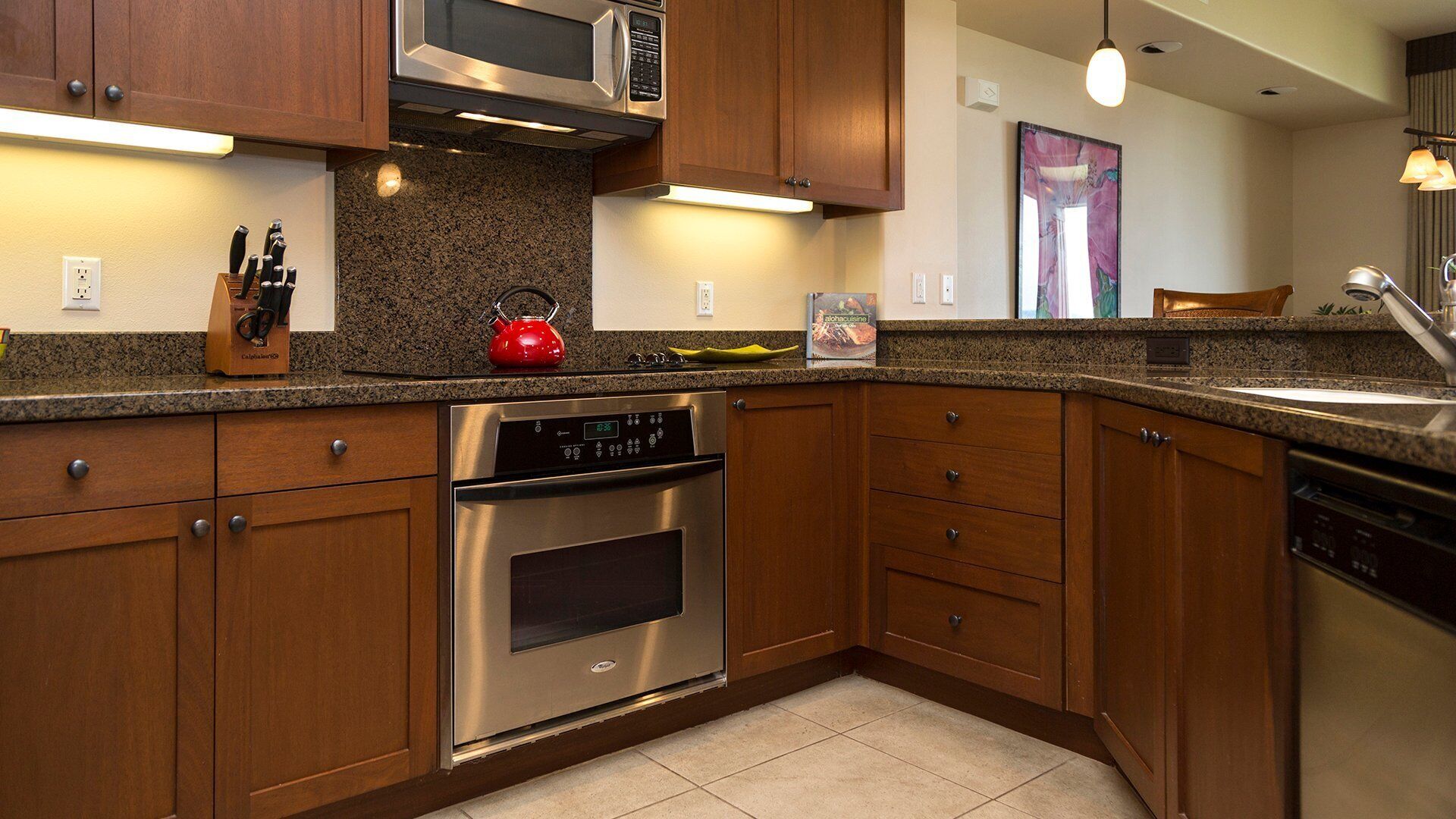 A modern kitchen with wooden cabinets, stainless steel appliances, and granite countertops.