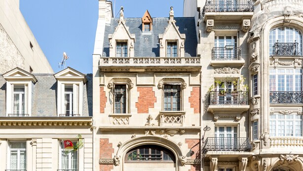 A row of historic buildings with ornate facades, large windows, and decorative balconies. - Merveil Signature Suite - Alfred (Paris)