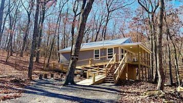 A cabin with a wooden deck, stairs, and a sign reading 'The Otter Box Cafe.'