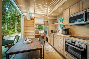 Una cocina moderna con armarios de madera, microondas integrado y un horno espacioso.