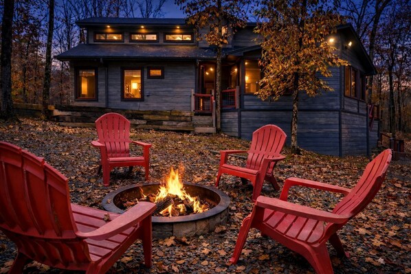 A cabin with a fire pit and four Adirondack chairs in front. - Stunning Cabin with Games Perfect for Families in Broken Bow, Oklahoma (Broken Bow)