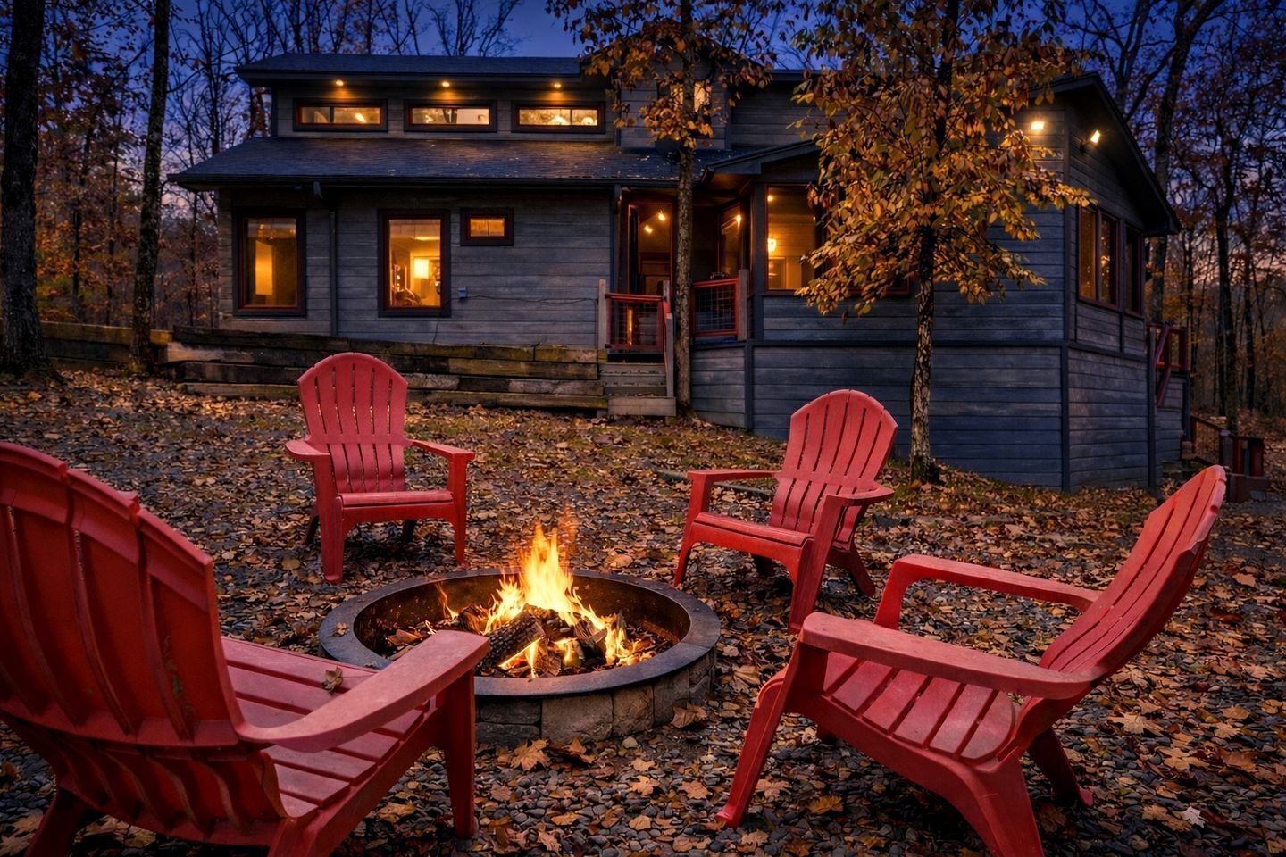 En hytte med bålsted og fire Adirondack-stole foran.