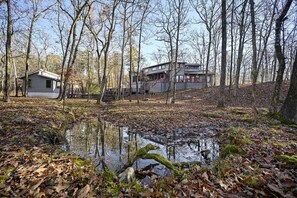 A cabin surrounded by trees and a small pond. - Stunning Cabin with Games Perfect for Families in Broken Bow, Oklahoma (Broken Bow)