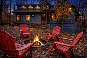 A cabin with a fire pit and four Adirondack chairs in front. - Stunning Cabin with Games Perfect for Families in Broken Bow, Oklahoma (Broken Bow)