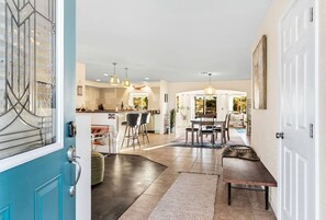 A spacious kitchen with a dining area, a bar, and a pool view. - Yucca Valley Wonderland: Embark on a Unique Desert Adventure (Yucca Valley)