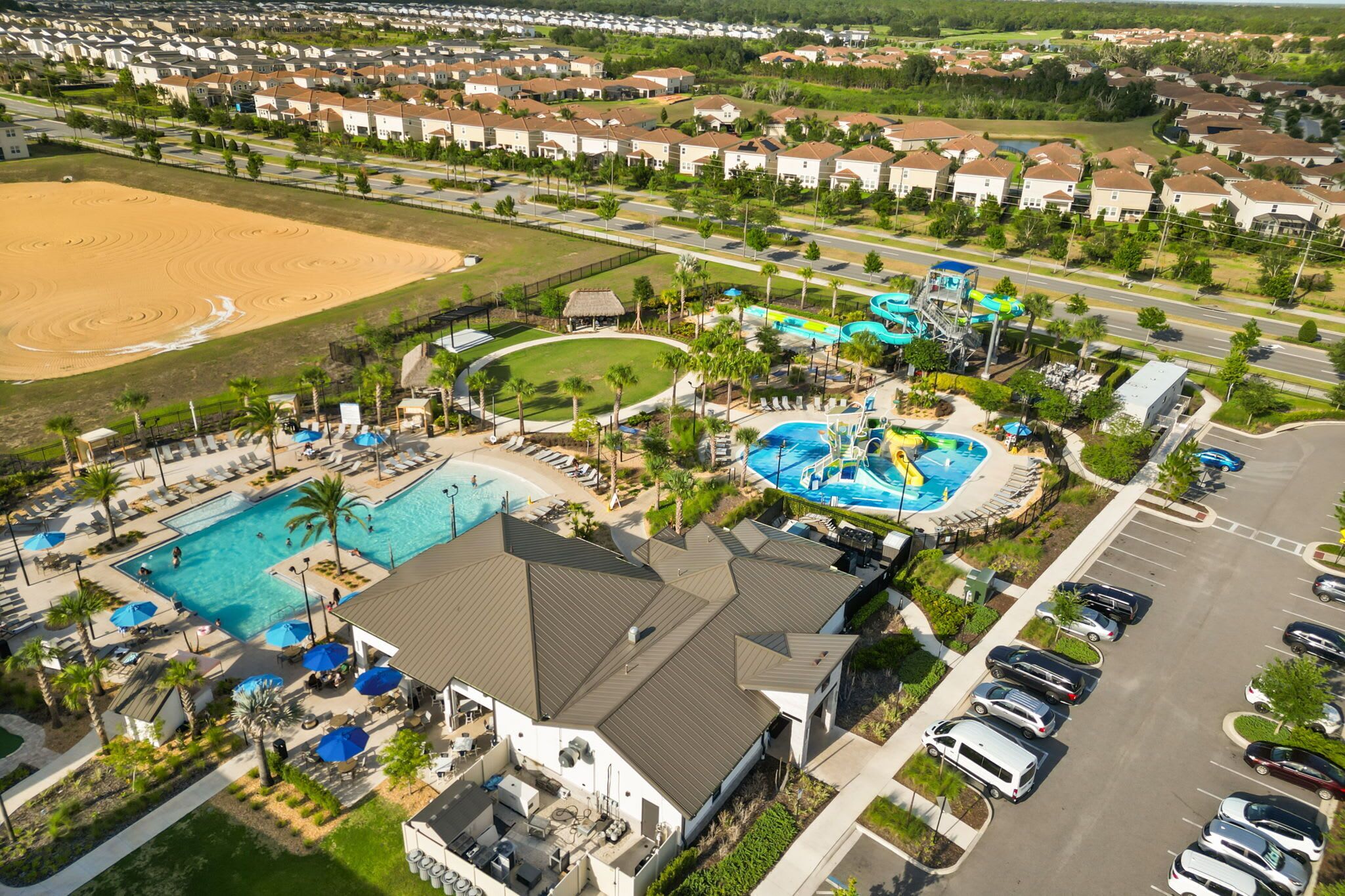 Oversigtsbillede af et resort med en stor swimmingpool, en vandpark og et sandstrandområde.