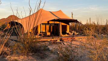 A desert tent with a covered porch and outdoor seating.