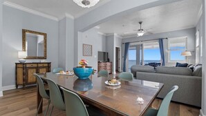 A dining area with a wooden table, chairs, a blue bowl, and a television.