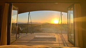 En autocamper med udsigt til solnedgang over et ørkenlandskab.
