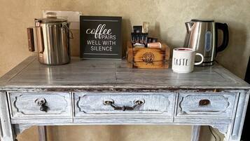 A rustic wooden table with a coffee pot, a mug, and a sign that reads 'coffee dupairs well with silence.'