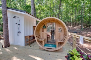 A wooden sauna structure with benches and a shower area.