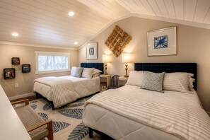 A bedroom with two beds, a window, wall art, and a patterned rug. - Embrace Nature in this Cozy Cabin with Fire Pit in Monteagle, Tennessee (Monteagle)