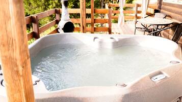 Un bain à remous sur une terrasse en bois, avec vue sur les arbres.