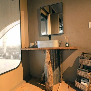 Ein Badezimmer mit einem Holzkosmetikschrank, einem Spiegel und einem Fenster.