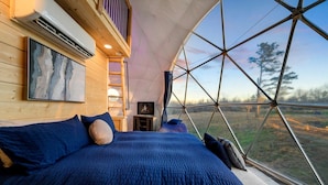 Una camera a tenda con un letto, un quadro e una televisione.