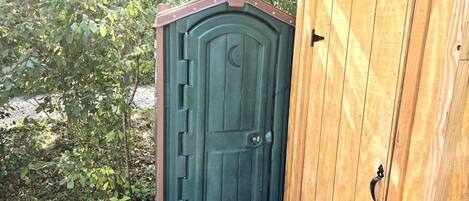 A wooden door with a crescent moon design, a metal handle, and a wooden frame.