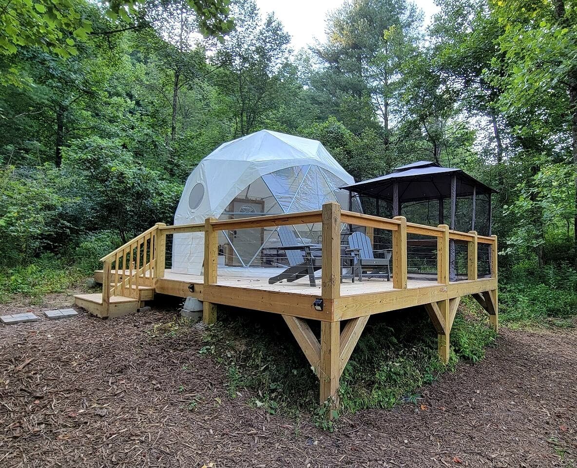 A wooden deck with a covered seating area and a gazebo.
