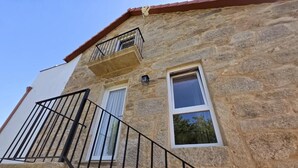 A stone building with a balcony, a staircase, and two windows. - Connect with yourself in a space of peace and tranquility. (Arbo)