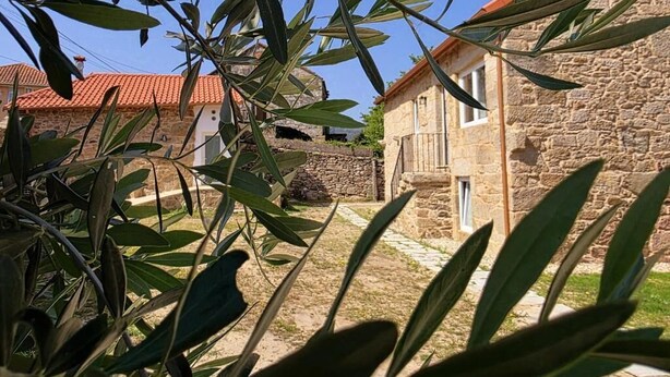 A stone building with a red-tiled roof, surrounded by olive trees. - Connect with yourself in a space of peace and tranquility. (Arbo)