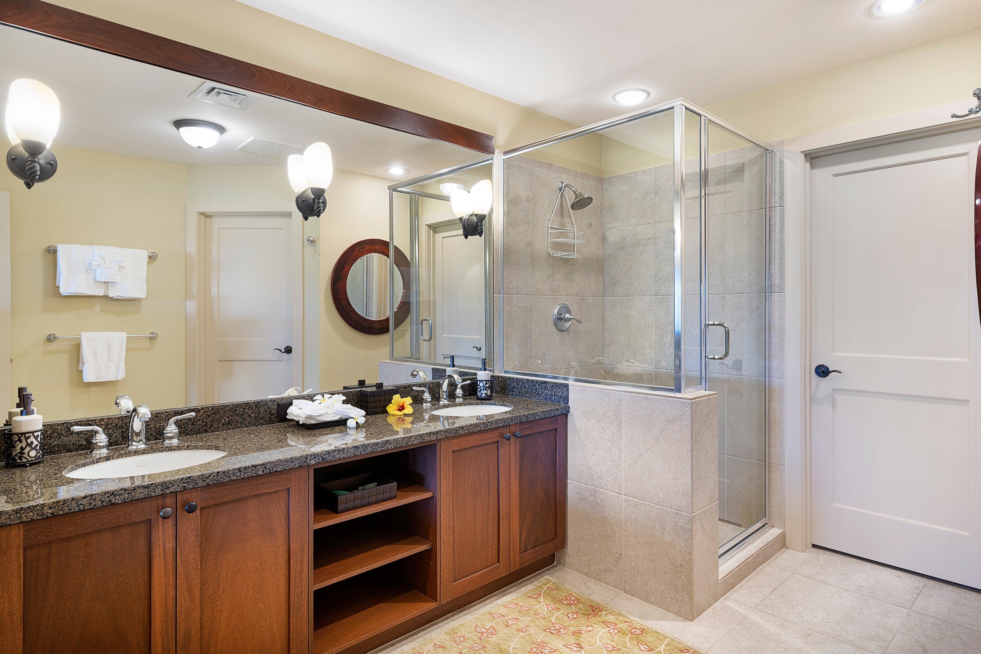 Une salle de bain moderne avec deux vasques, une douche en verre et un grand miroir.