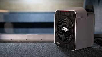 A portable air purifier with a visible brand logo and model name on the front.