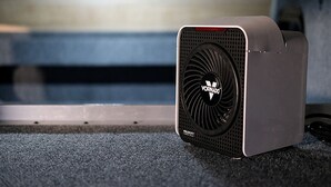 A portable air purifier with a visible brand logo and model name on the front.