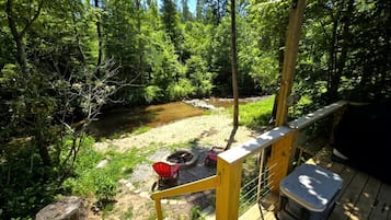 Une terrasse avec un foyer, des chaises et une glacière.