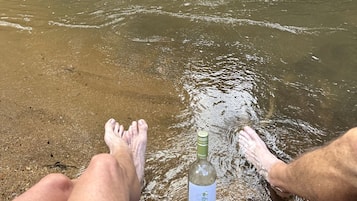 Een fles Seaglass wijn op een zanderig strand met helder water.