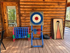 Eine Holzhütte mit einem Zielscheibenständer, einer Lochwand mit bunten Ringen und einem Dartboard.