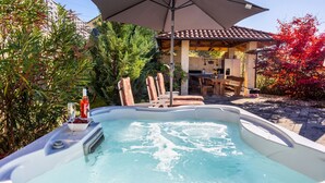 A hot tub with a table and chairs, surrounded by lush greenery and a pergola. - Villa Lemily with private pool by Villas Guide (Matulji)