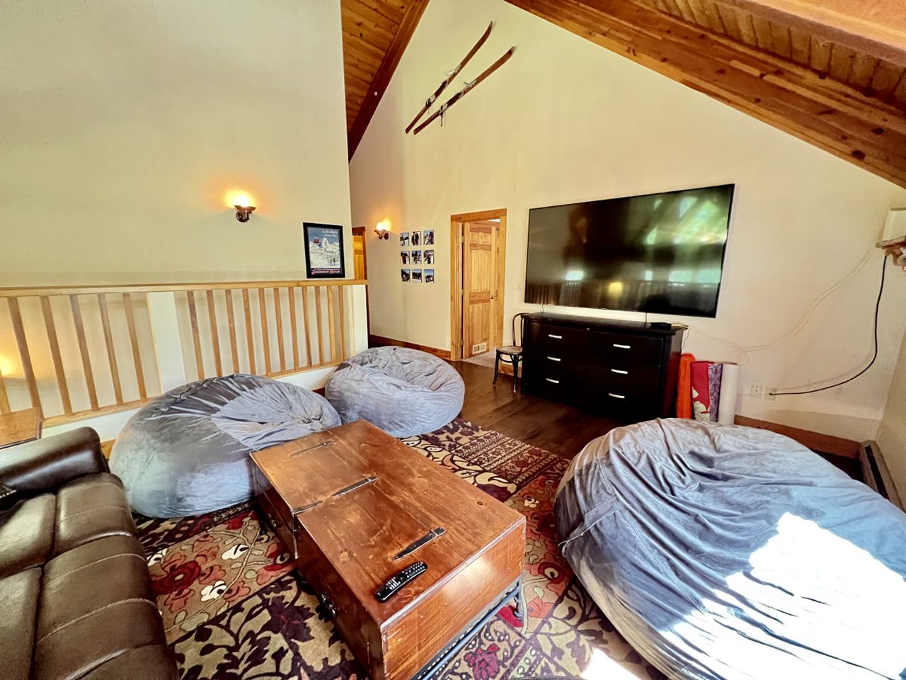 Una sala de estar acogedora con un sofá, sillones de peluche, una mesa de centro de madera, un televisor y una chimenea.
