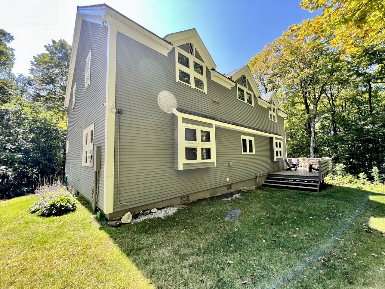 A two-story house with a front porch, a garage, and a well-maintained lawn.