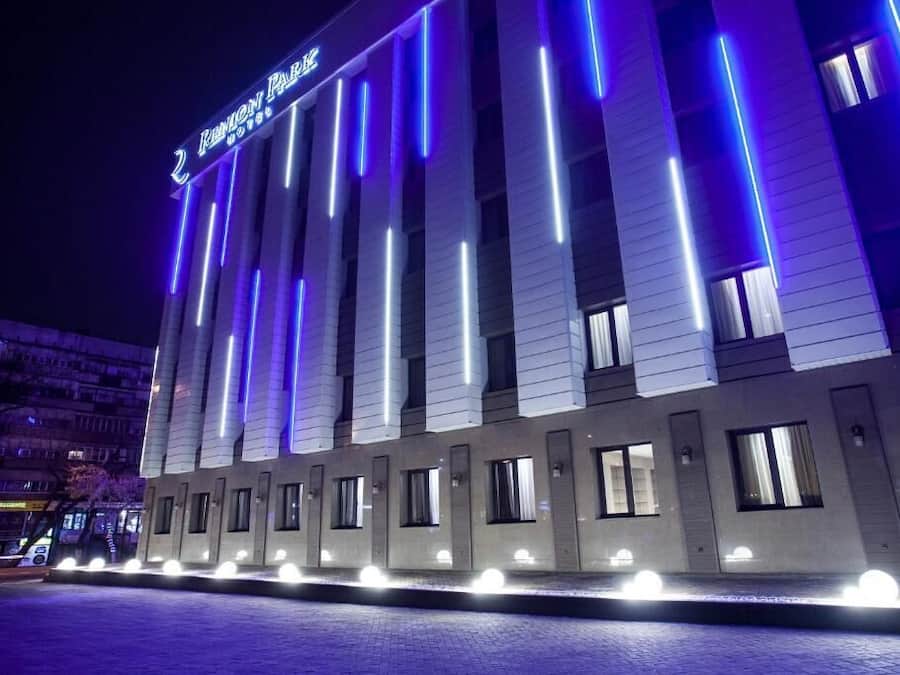 A hotel with a modern facade, illuminated by vertical blue lights, and a sign indicating it is the "Renaissance Park Hotel."