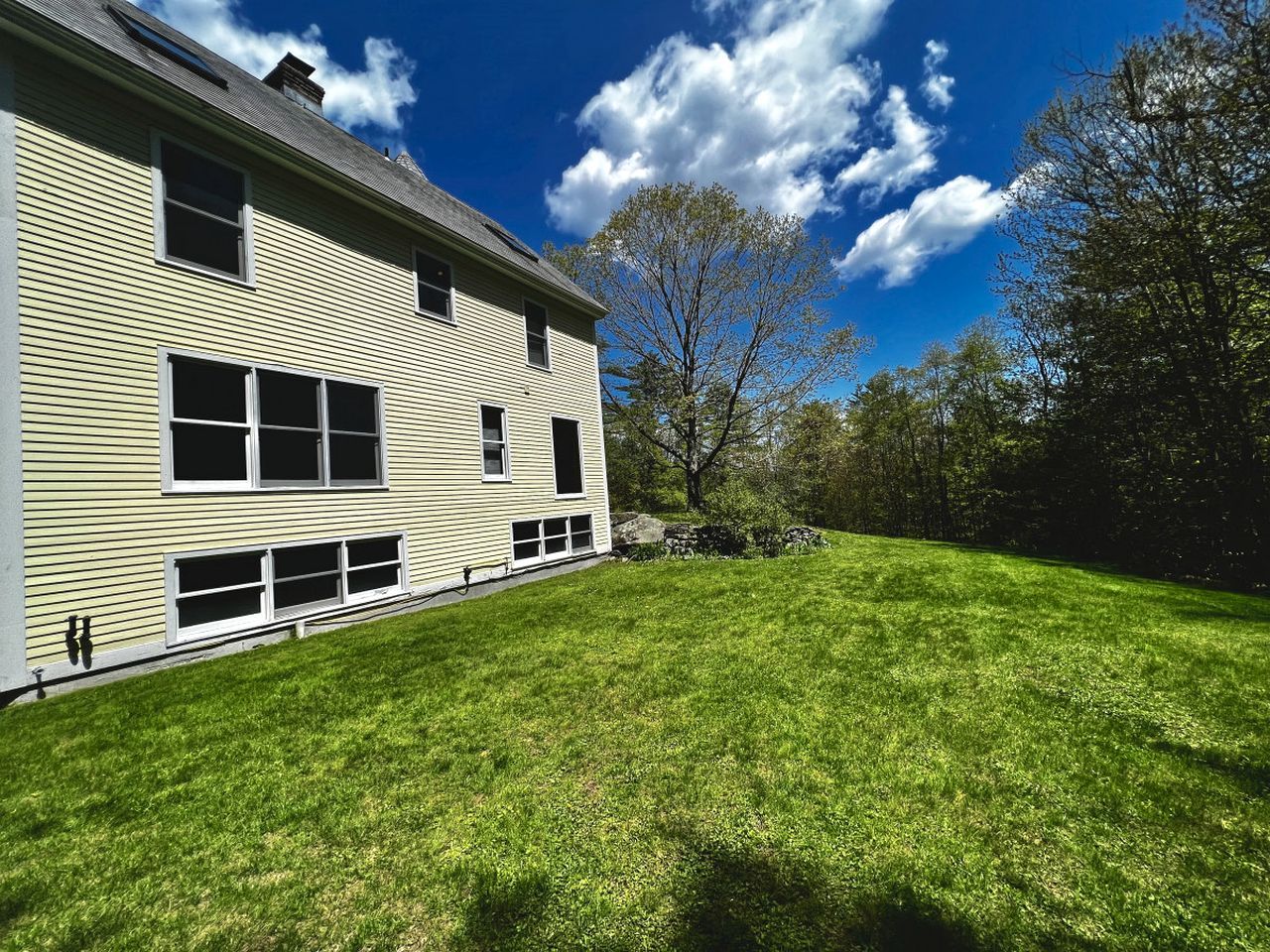 A two-story building with a large lawn in front.