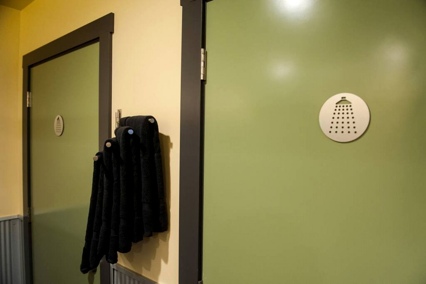 Une porte avec un porte-serviettes et un détecteur de fumée fixés au mur.