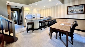 A hotel lobby with a dining area, a kitchen, and a staircase. - Mountain Cabin Great for a Family Retreat in Vermont (Stratton)