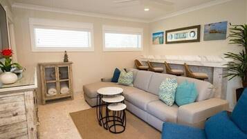 A living room with a sofa, a small table, a cabinet, and a fireplace.